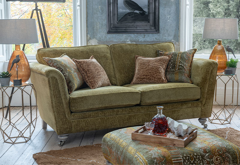Green sofa with decorative pillows in a living room setting