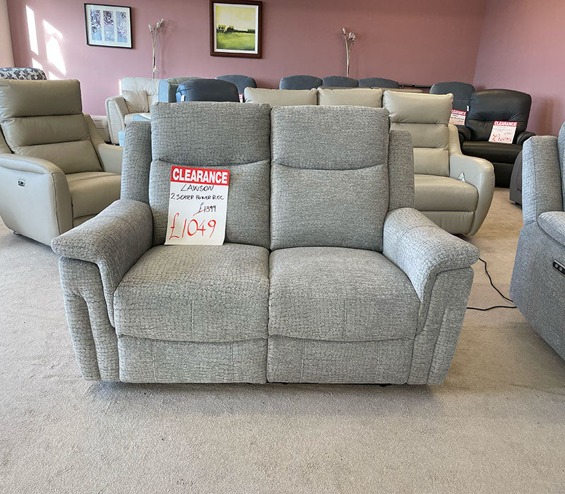 Grey 2-seater recliner sofa with a clearance sign in a showroom setting