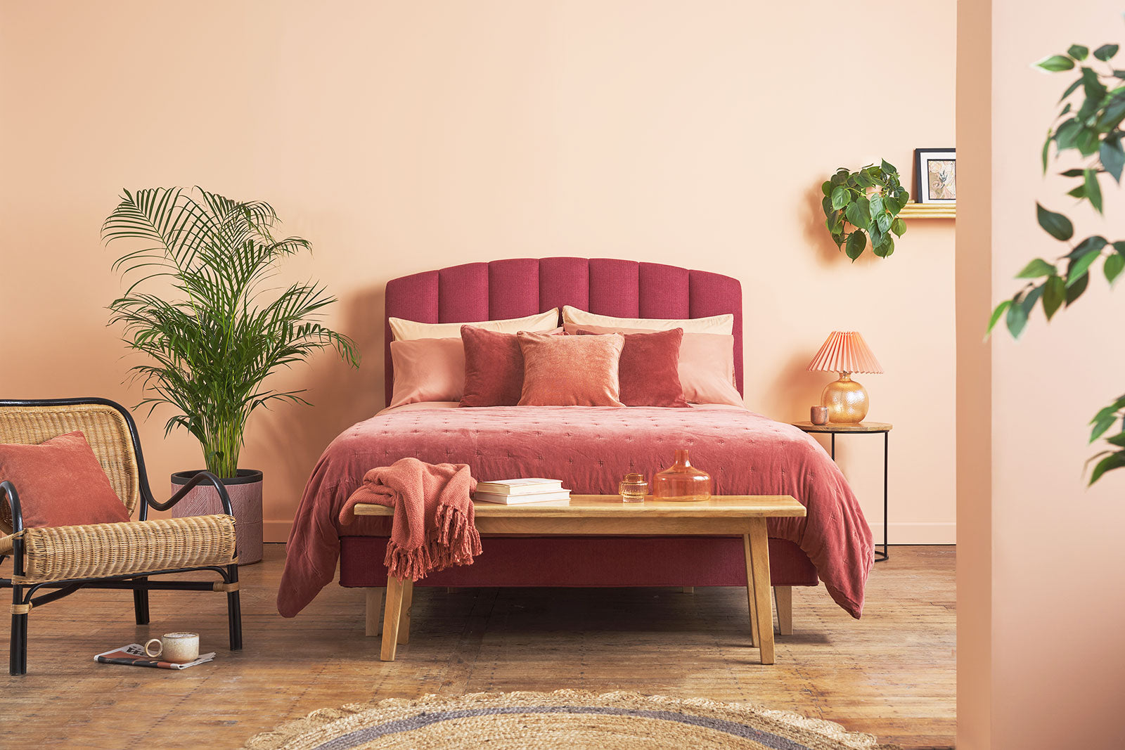 Pink bedroom with a Hypnos bed, chair, and decor elements.