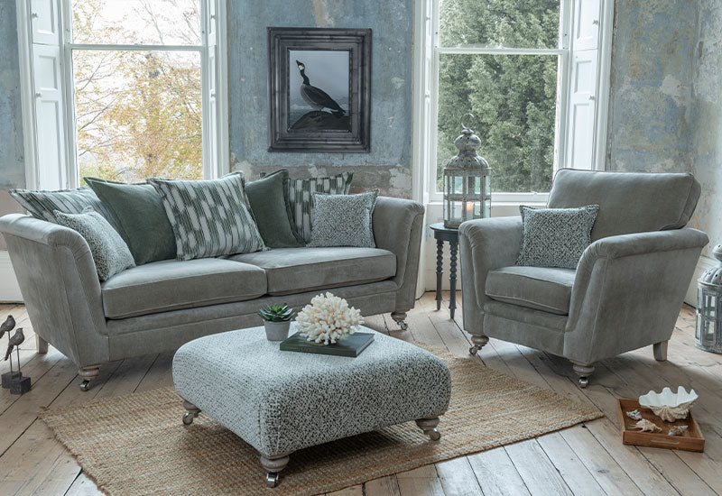 Greeny/grey sofa and armchair set in a living room with decorative elements.