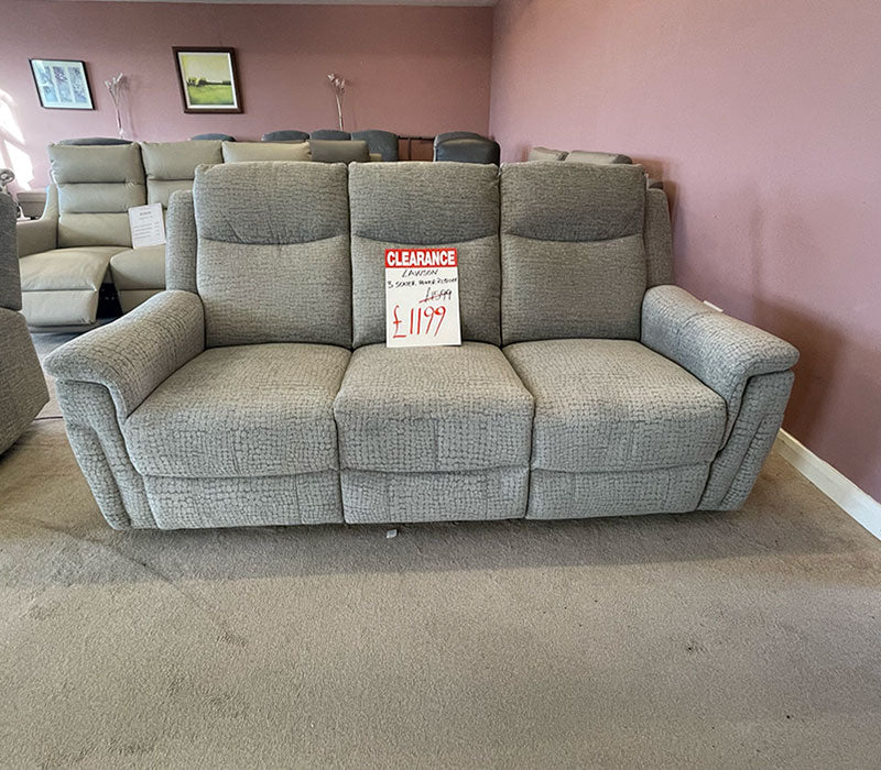 Grey sofa with a clearance sign in a showroom with other furniture