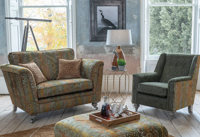 Living room with patterned sofa, armchair, and ottoman.