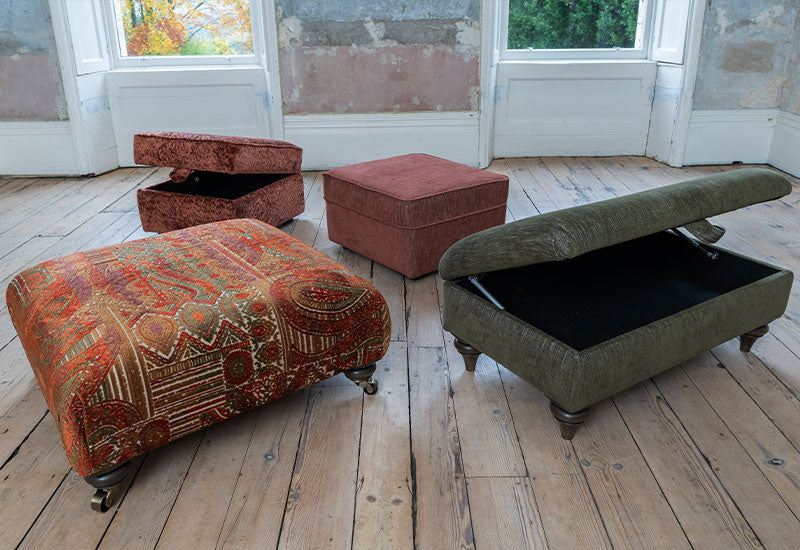 Three upholstered storage ottomans on a wooden floor with peeling paint walls.