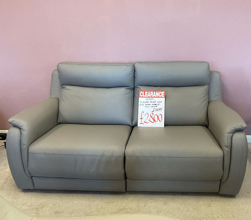 dark grey 3-seater leather sofa with a clearance sign in a furniture showroom