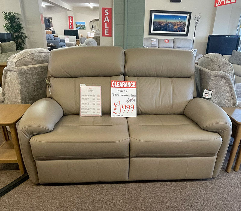 Cappucino coloured leather sofa with a clearance sign in a furniture shop