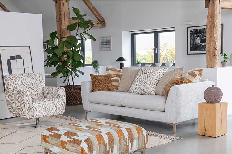 Modern living room with a white Inca sofa, patterned armchair, and ottoman.