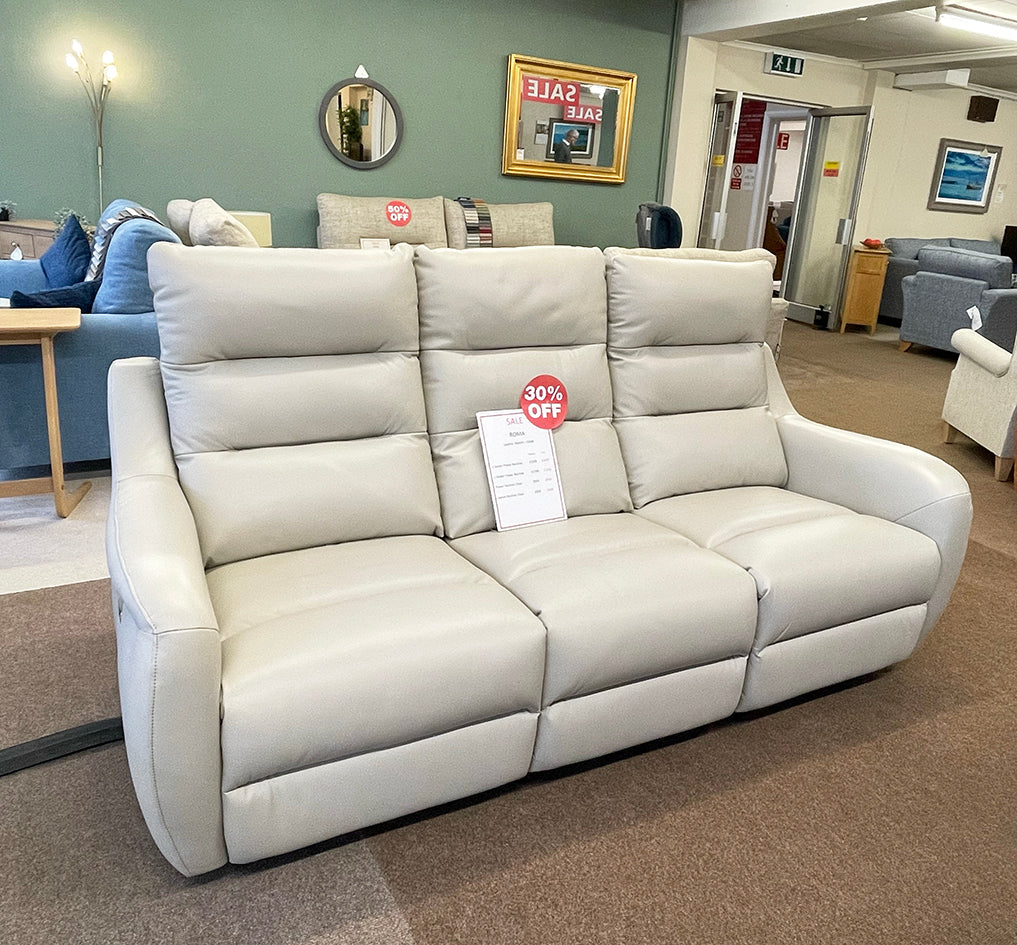 Roma 3-seater recliner leather sofa in a chalk colour in a furniture showroom with a discount sign 